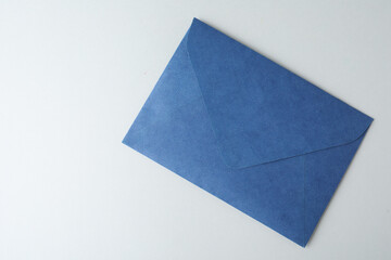 Blue paper envelope on light background, top view