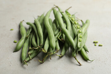 Fresh green beans on light grey table, closeup