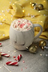 Composition with delicious marshmallow drink, festive decor and yellow sweater on light grey table