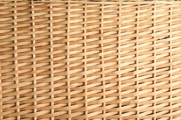 Handmade wicker basket made of natural material as background, closeup view