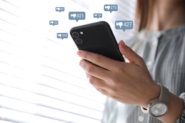 Closeup view of young woman using modern smartphone indoors and virtual dislike icons....