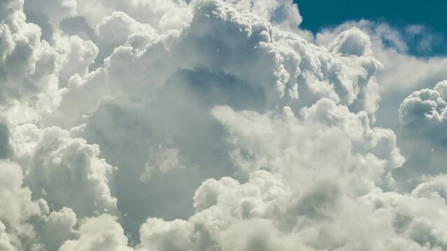 Timelapse of white puffy cumulus clouds forming on summer blue sky. Moving and changing cloudscape weather