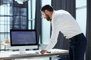Young business man working at home with laptop and papers on desk