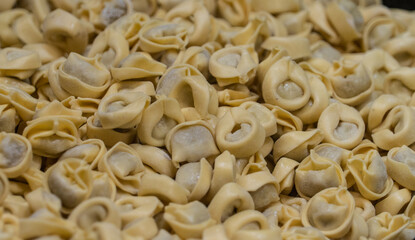 Close up view of ready to cook yellow color tortellini filled with meat at an Italian market