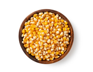 Dried corn kernels in wooden bowl placed on white background. Corn for popcorn.