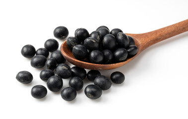 Black soybeans and a wooden spoon on a white background.