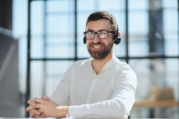 Smiling friendly handsome young male call centre operator.