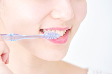 歯磨きする女性のクローズアップ　白背景