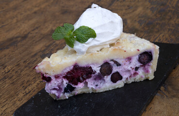 Sweet dessert. Closeup view of a slice of red berries crumble cake with cream cheese. 