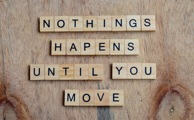 Nothings happens until you move text on wooden square, inspiration and motivation quotes