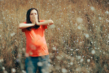 Pregnant Woman Sneezing from Allergies Standing in a flower meadow. Mother to be suffering an...