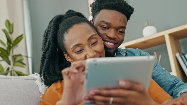 Love, sofa and black couple shopping on tablet while they relax together in the living room. African people compromise, decide and plan home, apartment or ecommerce order and delivery logistics.