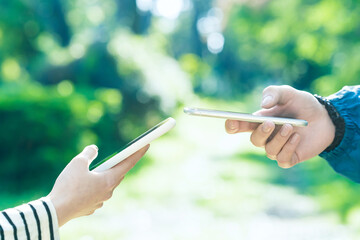 スマートフォンを操作する男女