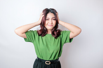 Portrait of young Asian woman isolated by white background feeling frustrated with helpless face...