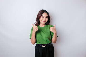 Excited Asian woman gives thumbs up hand gesture of approval, isolated by white background