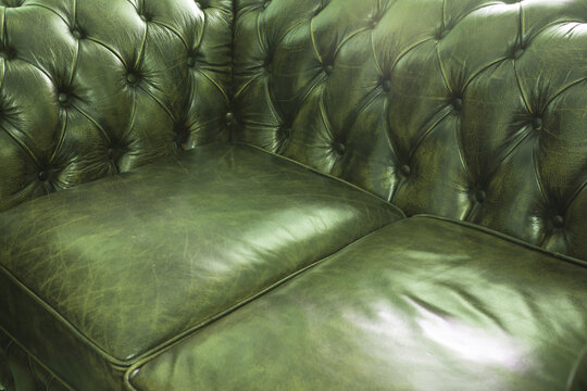 Green leather upholstered sofa in vintage button back Chesterfield style in a close up view