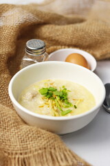 Asian congee with minced pork in white bowl.