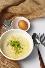 Asian congee with minced pork in white bowl.