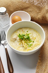 Asian congee with minced pork in white bowl.
