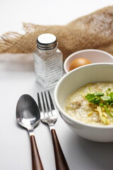 Asian congee with minced pork in white bowl.