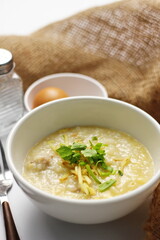 Asian congee with minced pork in white bowl.