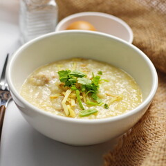 Asian congee with minced pork in white bowl.