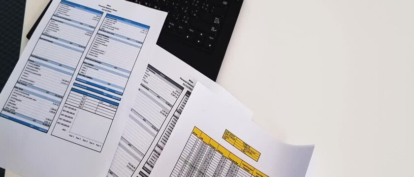 Slow motion footage of a person checking balance sheet and loan amortization table. Finance