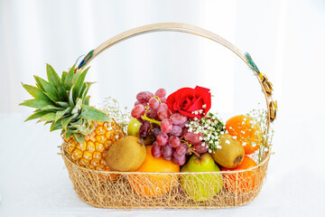 Large group of organic fresh fruits in a basket on white background.	