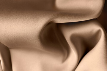 Beige color or light brown creased smooth luxury satin silk cloth texture decorate background with minimalistic style and space