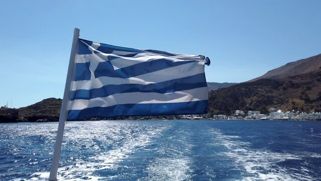 Greek flag on a boat leaving Loutro