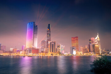 Obraz premium Beautiful view of Ho Chi Minh City skyline and the Saigon River at sunset. Amazing colorful view of skyscraper and other modern buildings at downtown