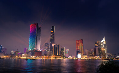 Fototapeta premium Beautiful view of Ho Chi Minh City skyline and the Saigon River at sunset. Amazing colorful view of skyscraper and other modern buildings at downtown