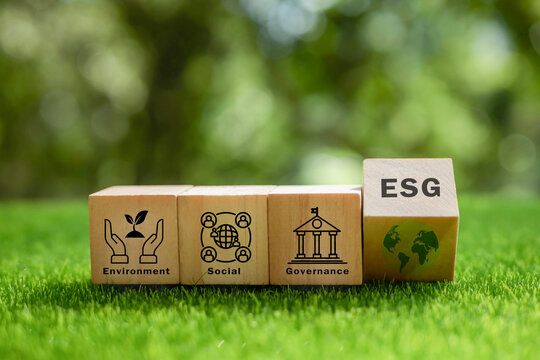 ESG concept of environmental, social and governance. Sustainable and ethical business. wooden cube with text "ESG" surrounding with ESG icon on beautiful green background. World environment day