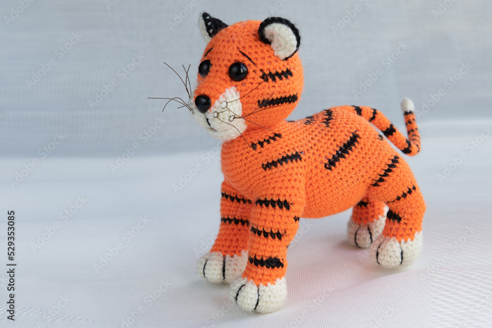 Wall mural Soft handmade amigurumi doll tiger cub. Symbol of 2022.