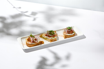 Aesthetic composition with tomato bruschetta on white background with harsh shadows. Italian...