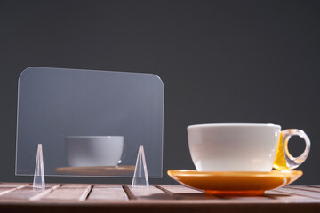 acrylic glass with stand for copy space and cup of coffee