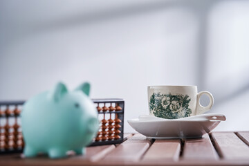 close up piggy bank and abacus and cup of coffee