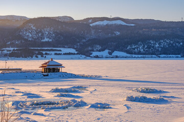 Sunset over the frozen and snow covered Saguenay fjord in Anse Saint Jean village, in Quebec (Canada)