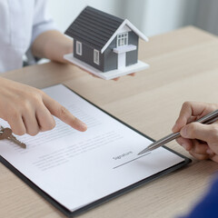 Fototapeta premium Contract signing, Home broker or salesperson allows customers to sign a contract to purchase a home as a legitimate homeowner. Transfer of ownership