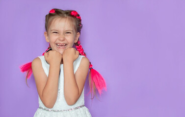Excited, overjoyed, the girl feels happy, looking at the camera on a purple background, rejoicing in her success and victory, clenching her fists with joy. Positive emotions, feelings