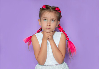 little smiling girl asks, begs for something, asks for forgiveness, has a surprised expression on...