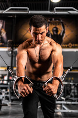 Fototapeta na wymiar High quality photo. Bodybuilder training. Hispanic man with weight training in gym equipment sport club. Man training with crossover in the gym. Man pulling cables training chest.