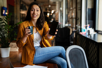 Young businesswoman drinking coffee in her office. Woman enjoy in coffee break..