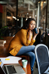 Young businesswoman drinking coffee in her office. Woman enjoy in coffee break..