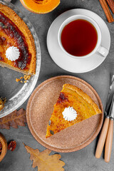  A piece of traditional American pumpkin pie with pecans and a cap of tea top view vertical photo, homemade pumpkin pie top view, pumpkin baked