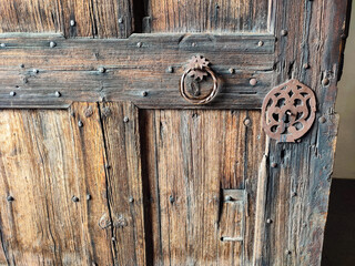 Alte Türbeschläge und ein Türklopfer aus Metall an einer mittelalterlichen Holztür