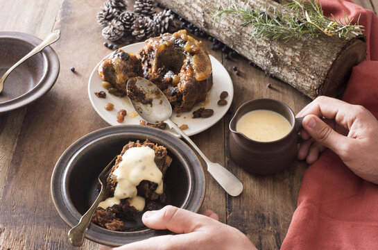 Man Serving Brandy Sauce On A Christmas Pudding