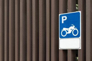 Motorcycle parking sign shown on dark brown wooden wall background.