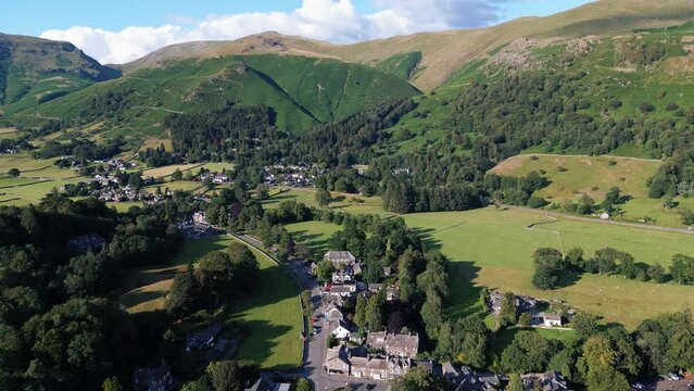 Aerial, drone, video footage Grasmere Village, Town in the Cumbrian Lake District National Park England UK on a beautiful sunny day