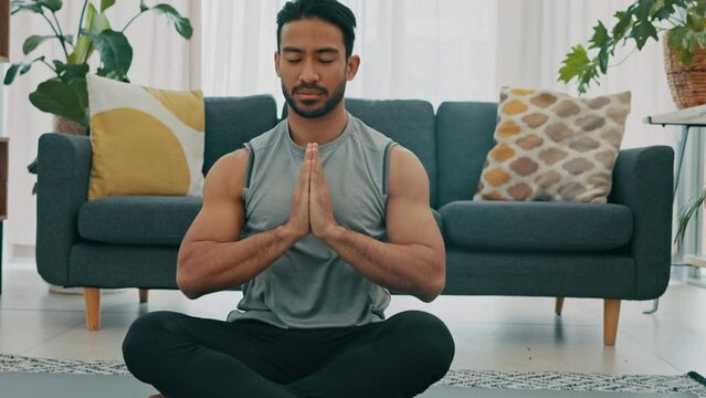 Wellness, yoga and meditation man on the floor in meditating training, practice or zen apartment. Calm young fitness guy meditate in living room on mat for healthy, spiritual and self care lifestyle